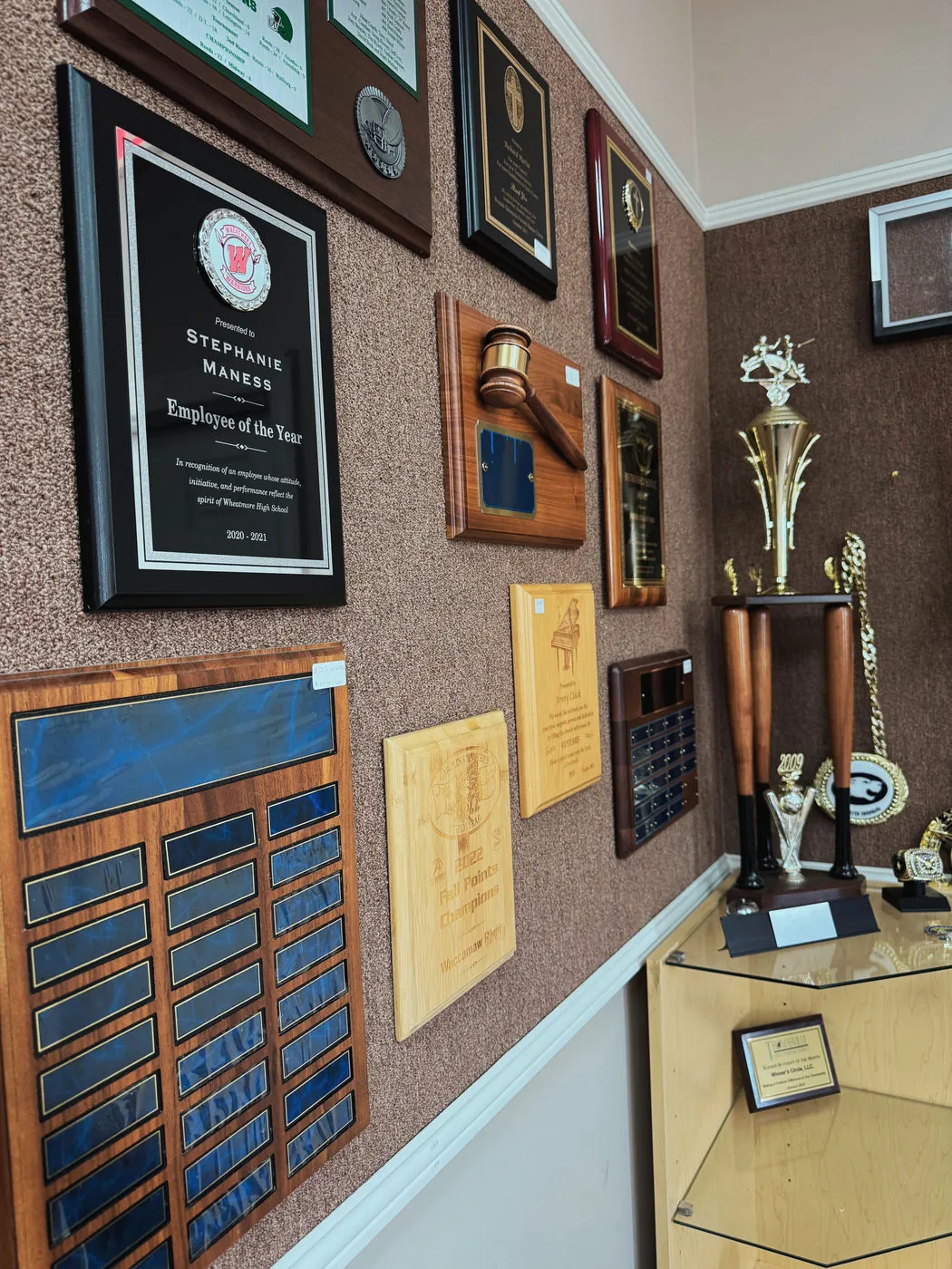 A wall of engraved plaques and trophies in the showroom