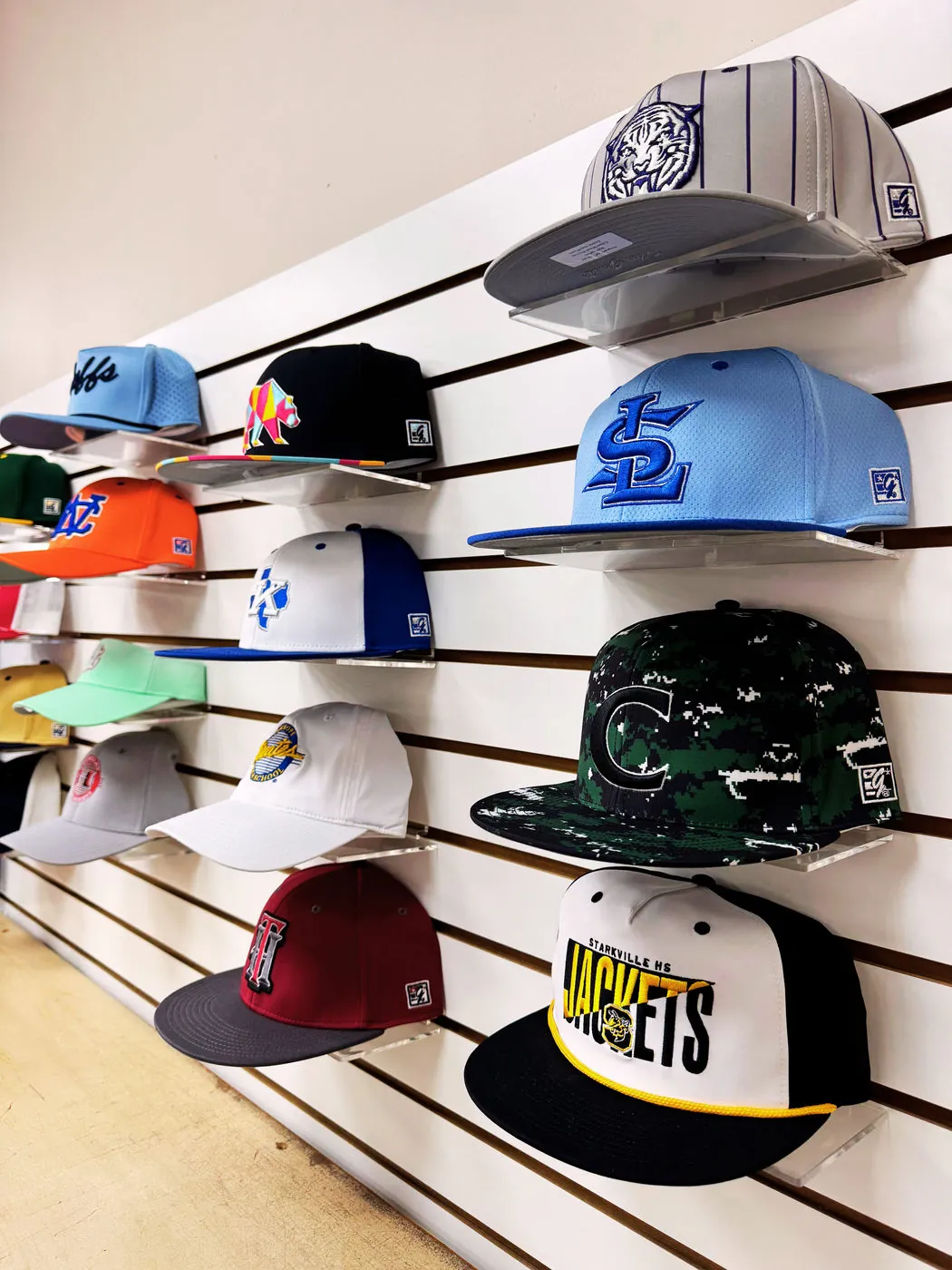 Embroidered team caps on the showroom wall