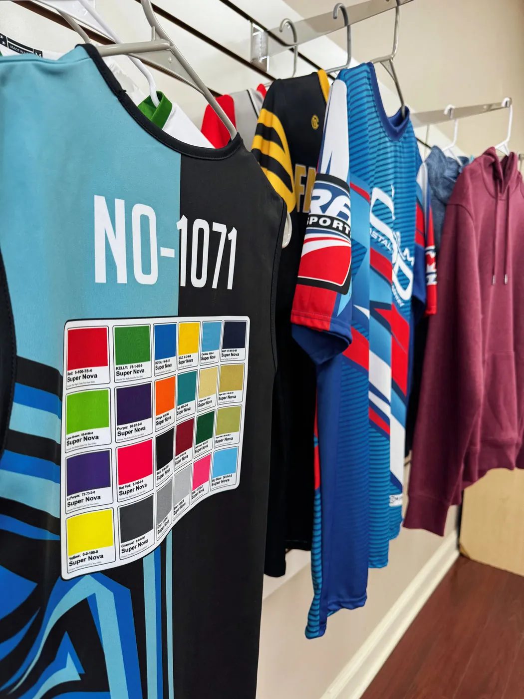 Custom sublimated team jerseys hanging on the rack in the shop