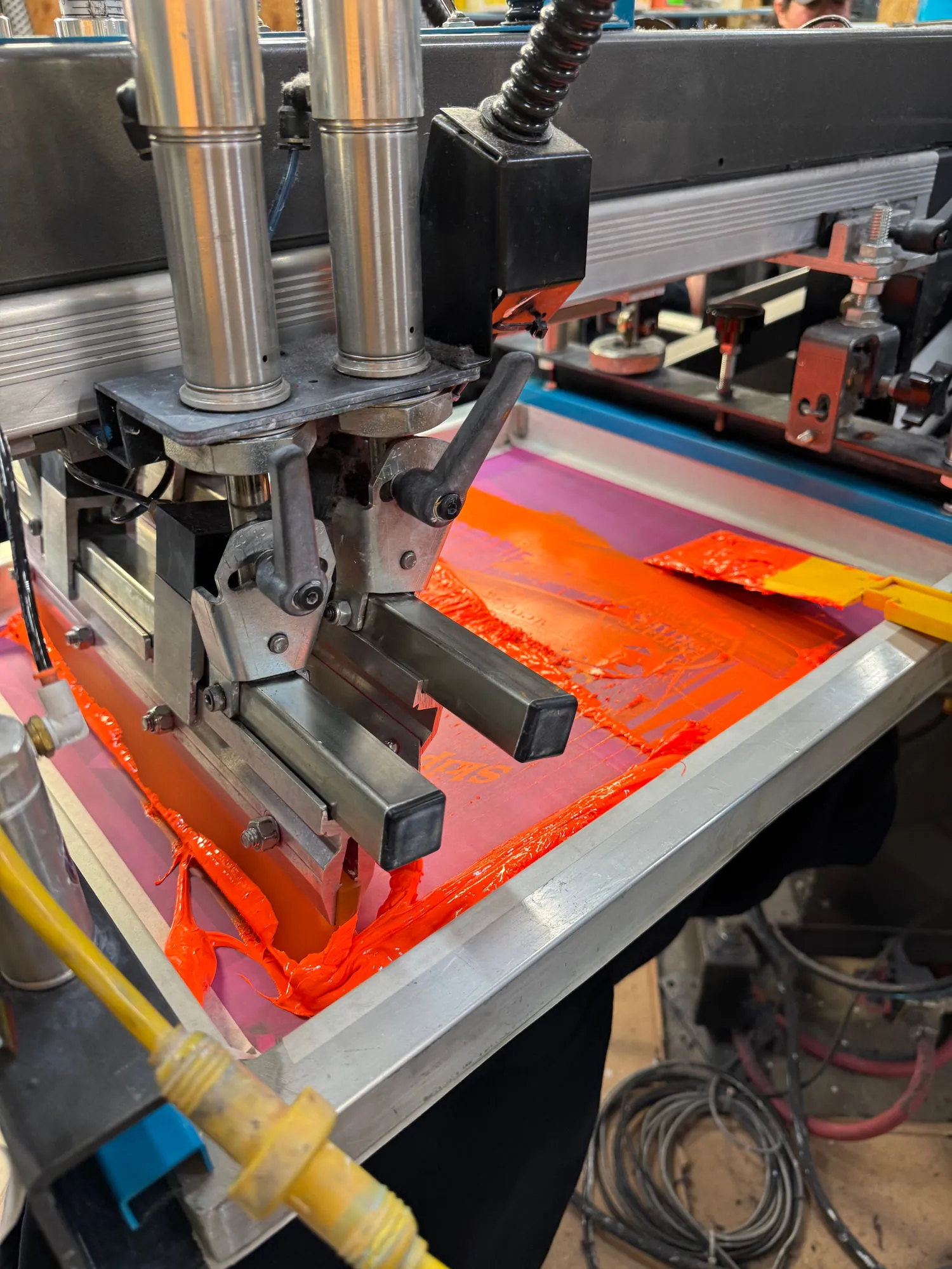 Ink being pulled across a screen on the press