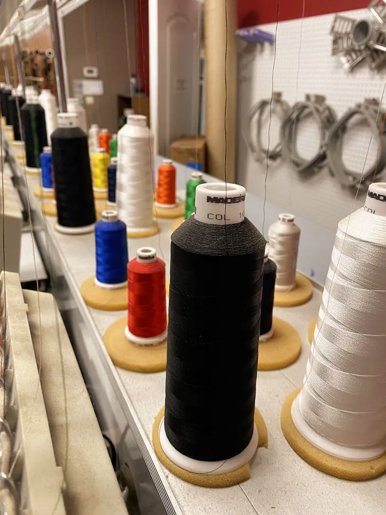 Rows of Madeira embroidery thread cones beside the machine