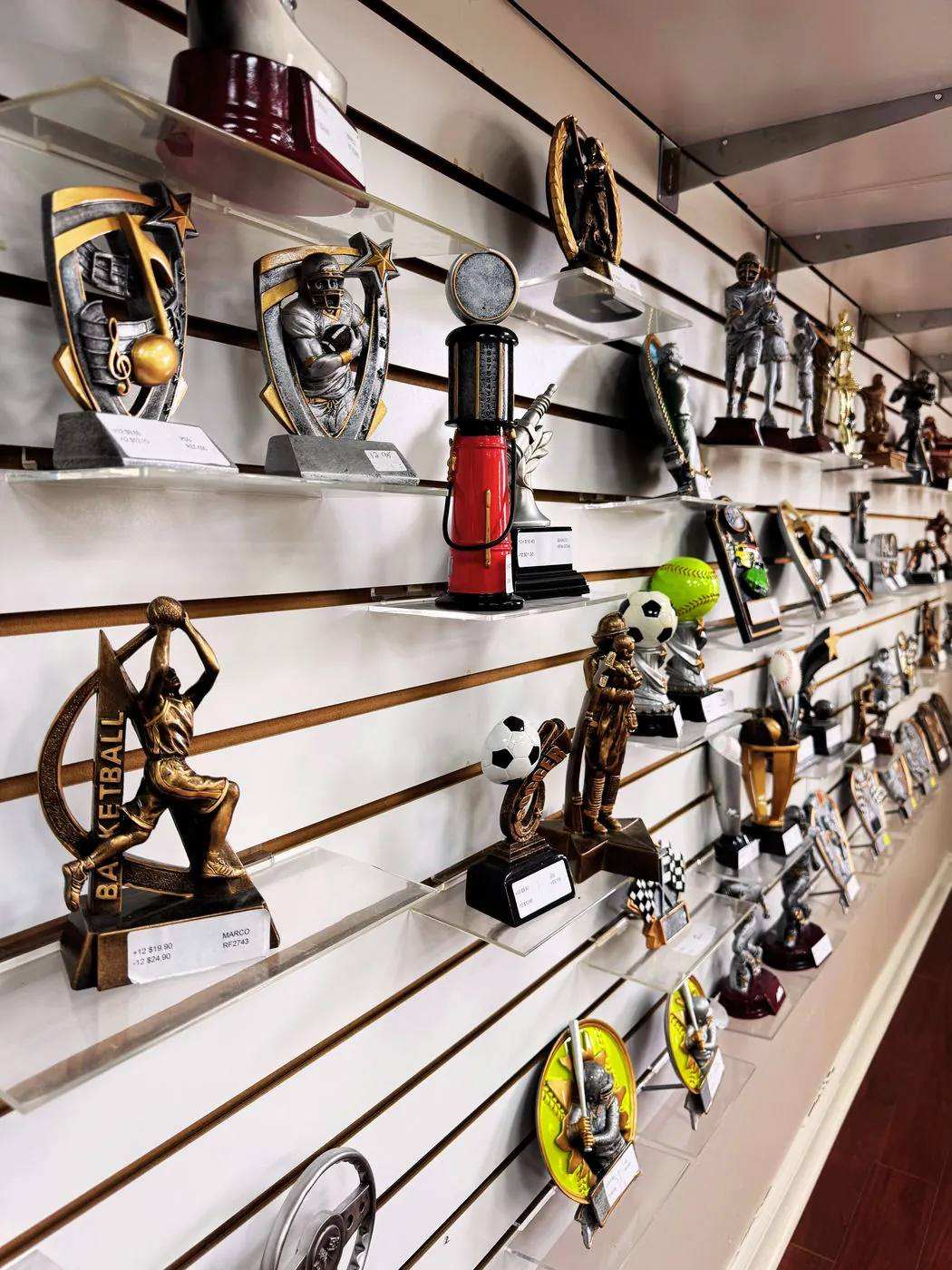 Showroom shelves lined with sports trophies and resin awards